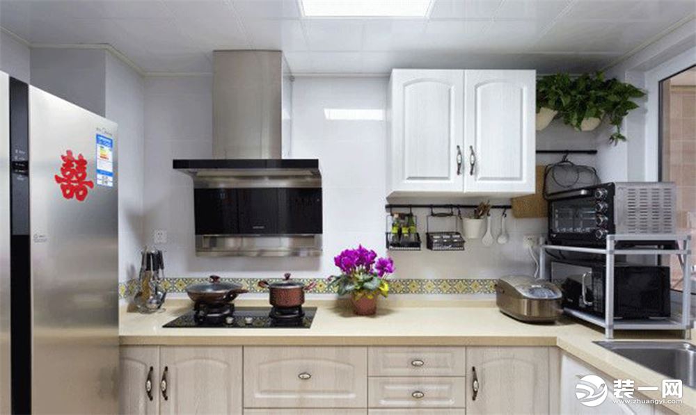 厨房真的很有“家的感觉”，都是很常见的橱柜和家电，温暖的米白色还有几分田园风格的意思。