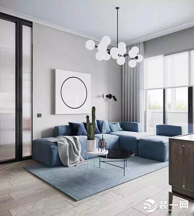 客厅采用蓝色地毯，将宁静与柔和拉进空间。墙面的圆形挂画，与吊灯上的圆球色调相匹配，象征出家庭的和谐美