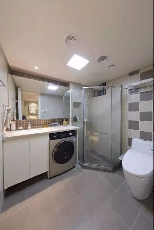 卫生间里做了干湿分离 把淋浴房放在角落 两侧摆放洗手台和马桶 洗衣机嵌在了洗手台之中 更省空间