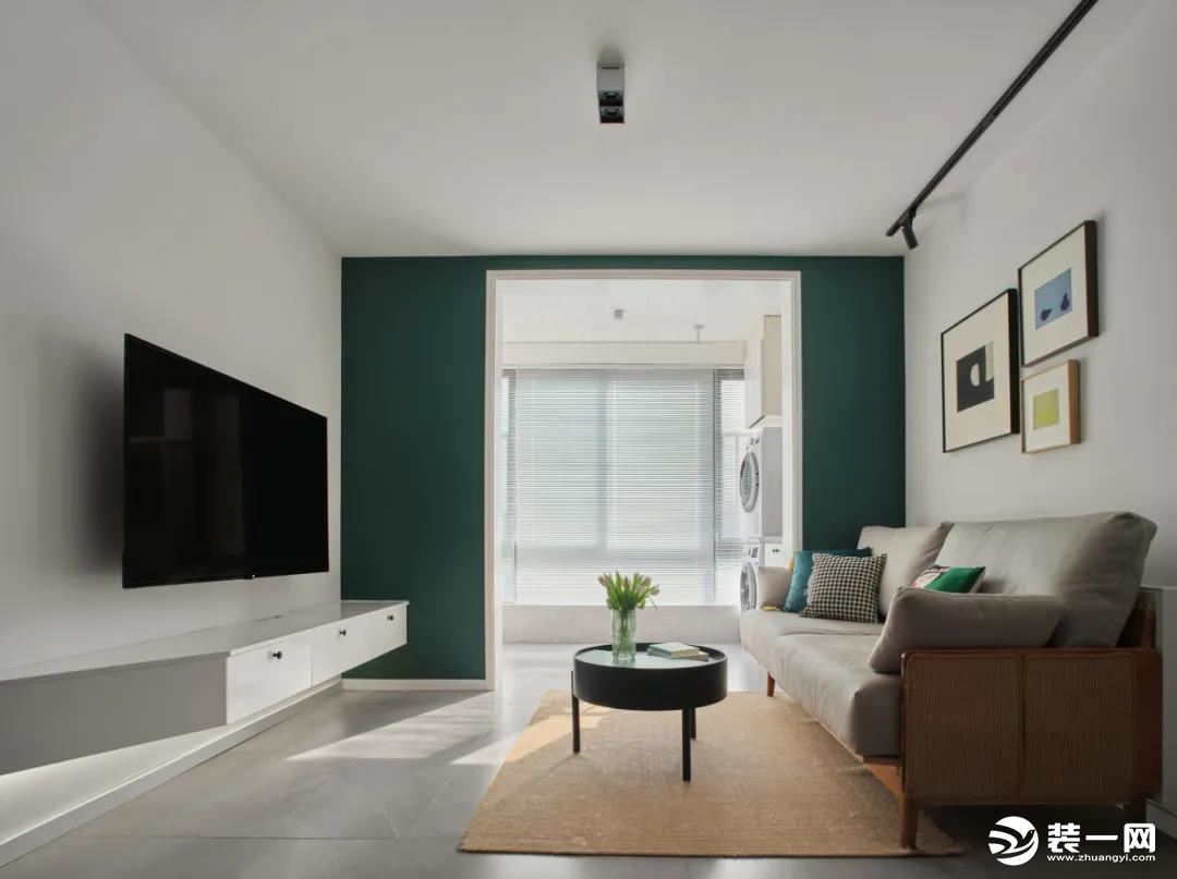 客厅：客厅与阳台打通，让自然光线更好的照进室内，以一面墨绿色墙面作为阳台与客厅区域划分，让人眼前一亮