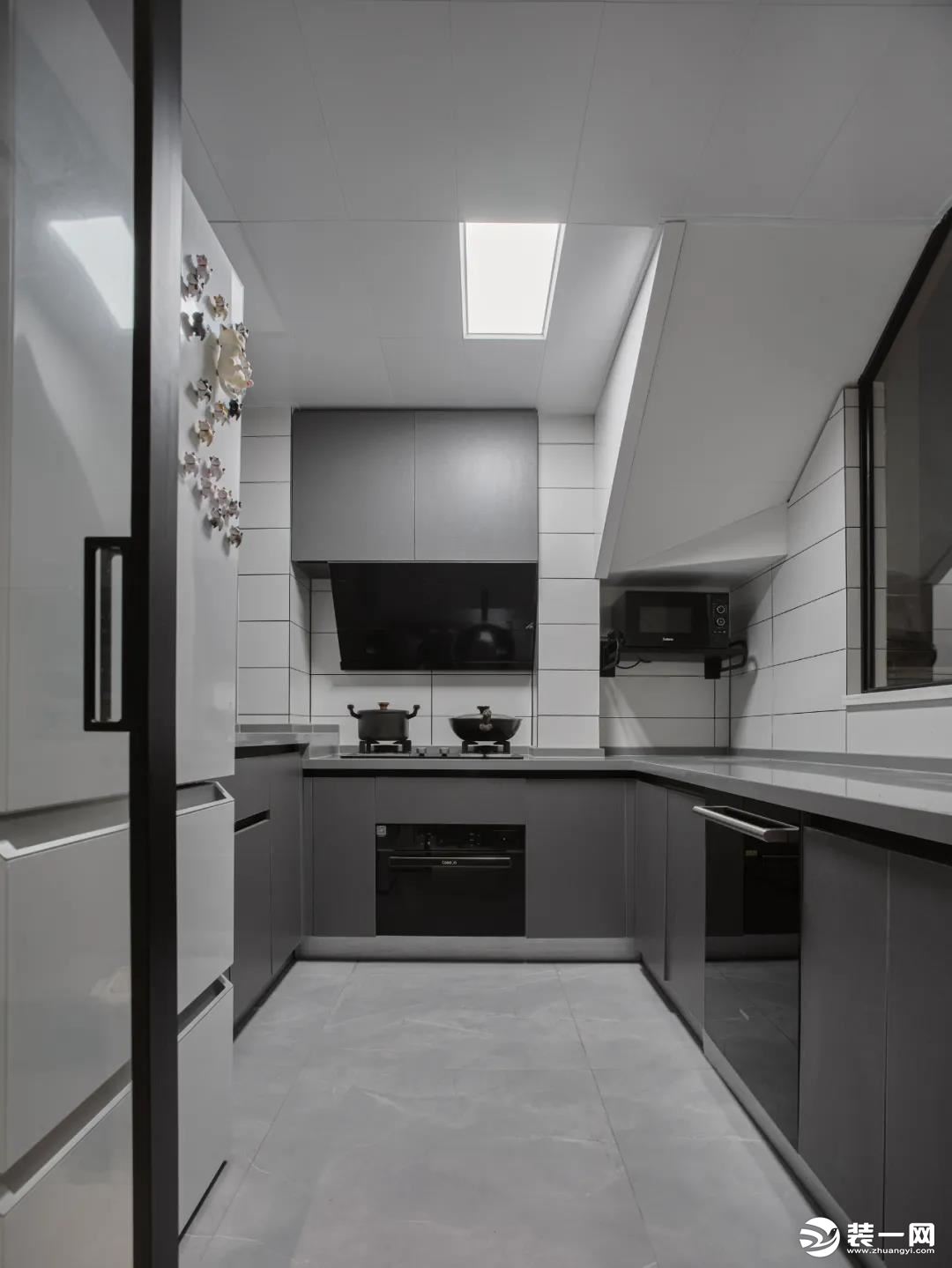 厨房：改造后的厨房空间，采用U型布局，利用率高。墙面白色砖搭配深灰色橱柜简洁利落