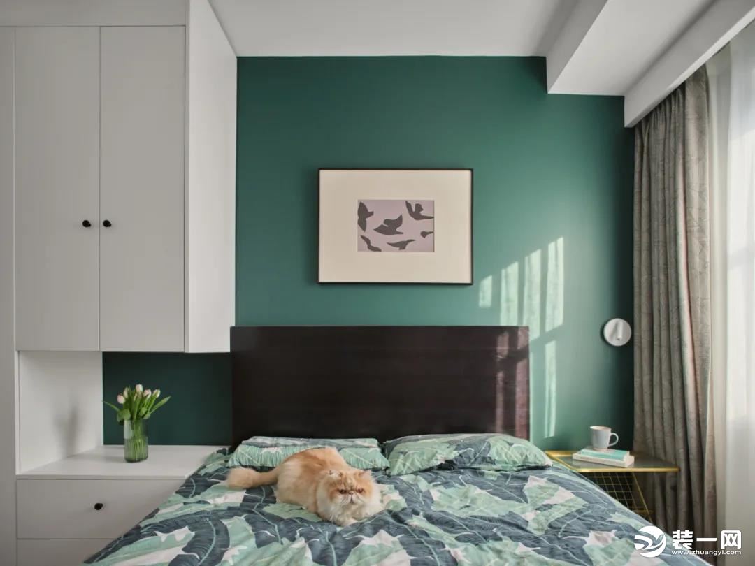 次卧：背景选择了复古的黑绿色，搭配棕色的床头靠背，营造出复古优雅，低调稳重的空间感