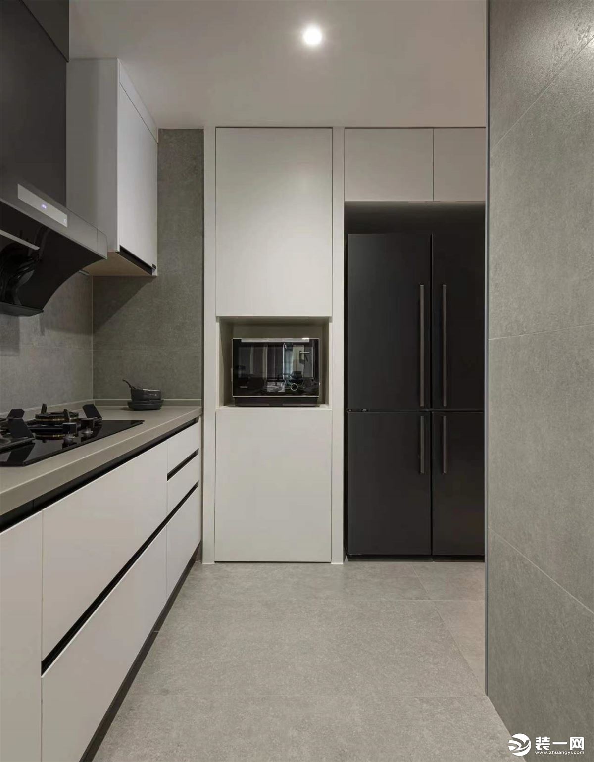 这是厨房的照片，拆除厨房和仓储间的墙体，设计“L”型厨房，利用嵌入式厨电，获得更多的料理空间。
