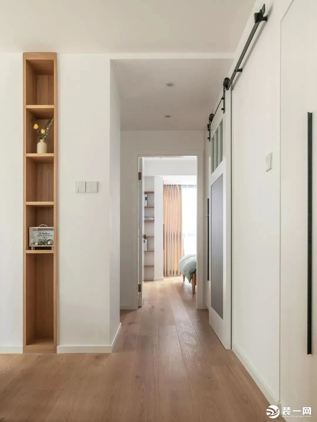 这条走廊通往卧室和卫生间，木地板搭配大白墙简单耐看。