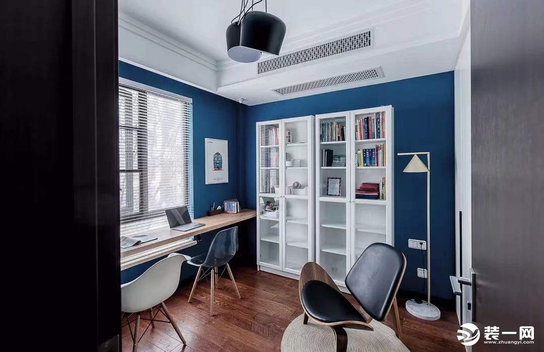 书房以蓝色为基调，搭配白色书柜、装饰画及落地灯，色彩对比鲜明。