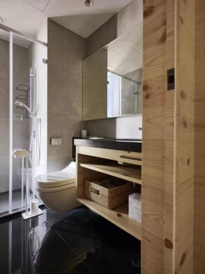 卫生间内用亮黑色的地砖搭配灰色调的墙砖木质感的浴室柜和门框作为过渡干湿分离的卫生间也有着足够的收纳。
