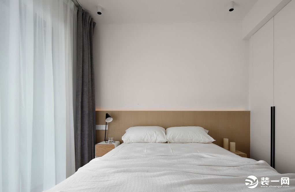 相比主卧室的现代简约，次卧室带了些许日式元素，木饰面板的半墙设计隐入线形灯带