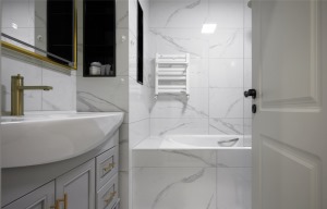 主卧卫生间使用壁龛做收纳，不占用使用空间。黄铜五金与卫浴用品，将空间点缀得优雅十足。