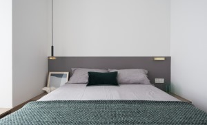 床头简单的灰色床头板让整个白色的空间里多了一些层次。