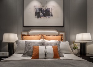  臥室背景墻懸掛藝術畫，橘黃色抱枕緩解空間的沉悶，設置臥室小書房，給躁動的心一些閑情逸致。