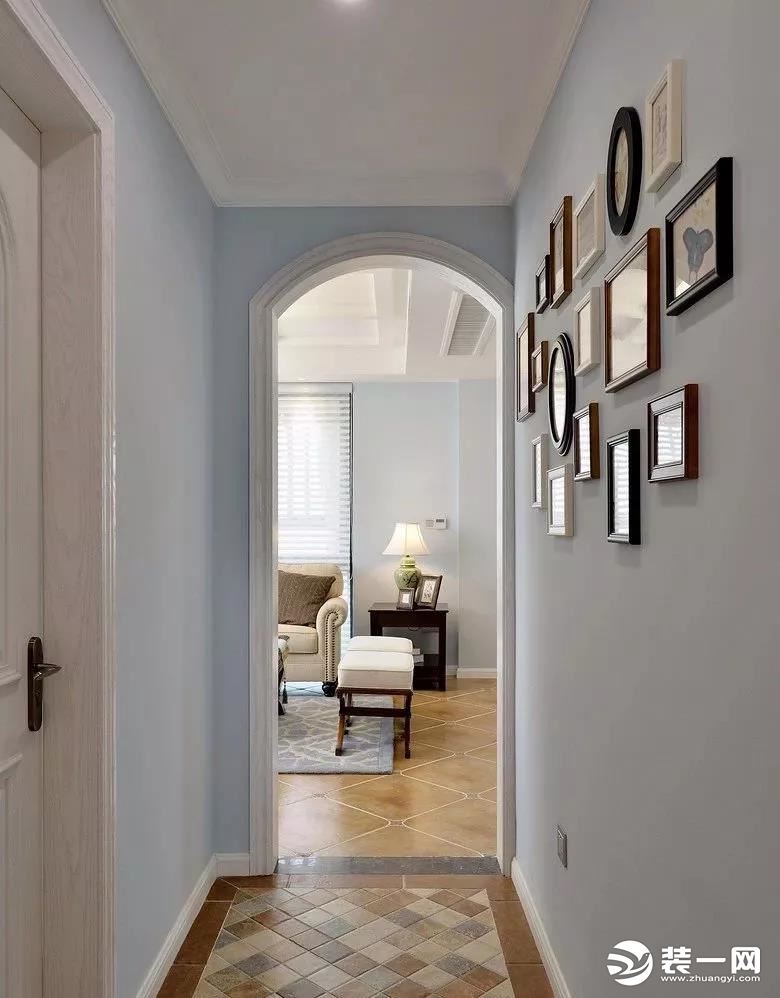 走廊 走廊与客厅隔着一个拱形门，采用与玄关一致的仿古马赛克地砖，淡蓝色的墙面上挂上一组的照片墙，让空