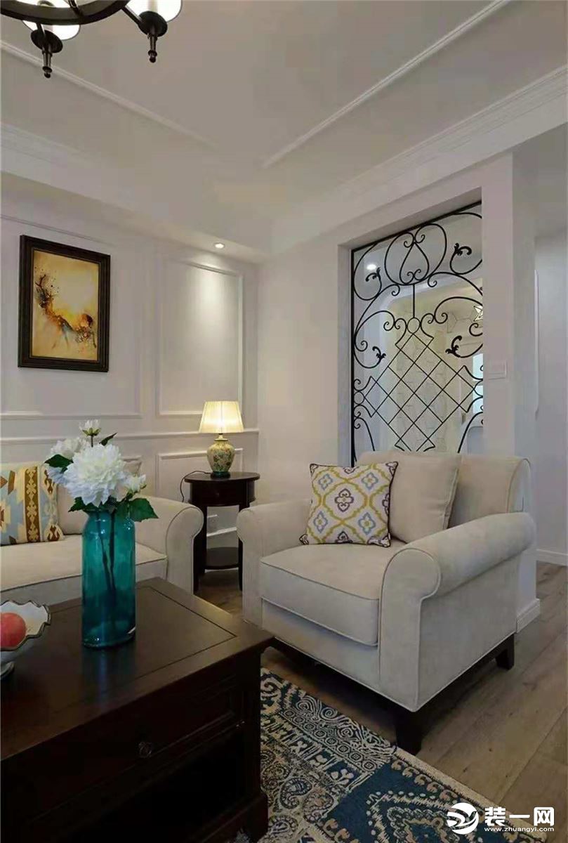  家具选用经典HH款型，浅灰色沙发背景用石膏线打造了护墙板效果，与家具颜色形成鲜明的对比，优雅沉稳