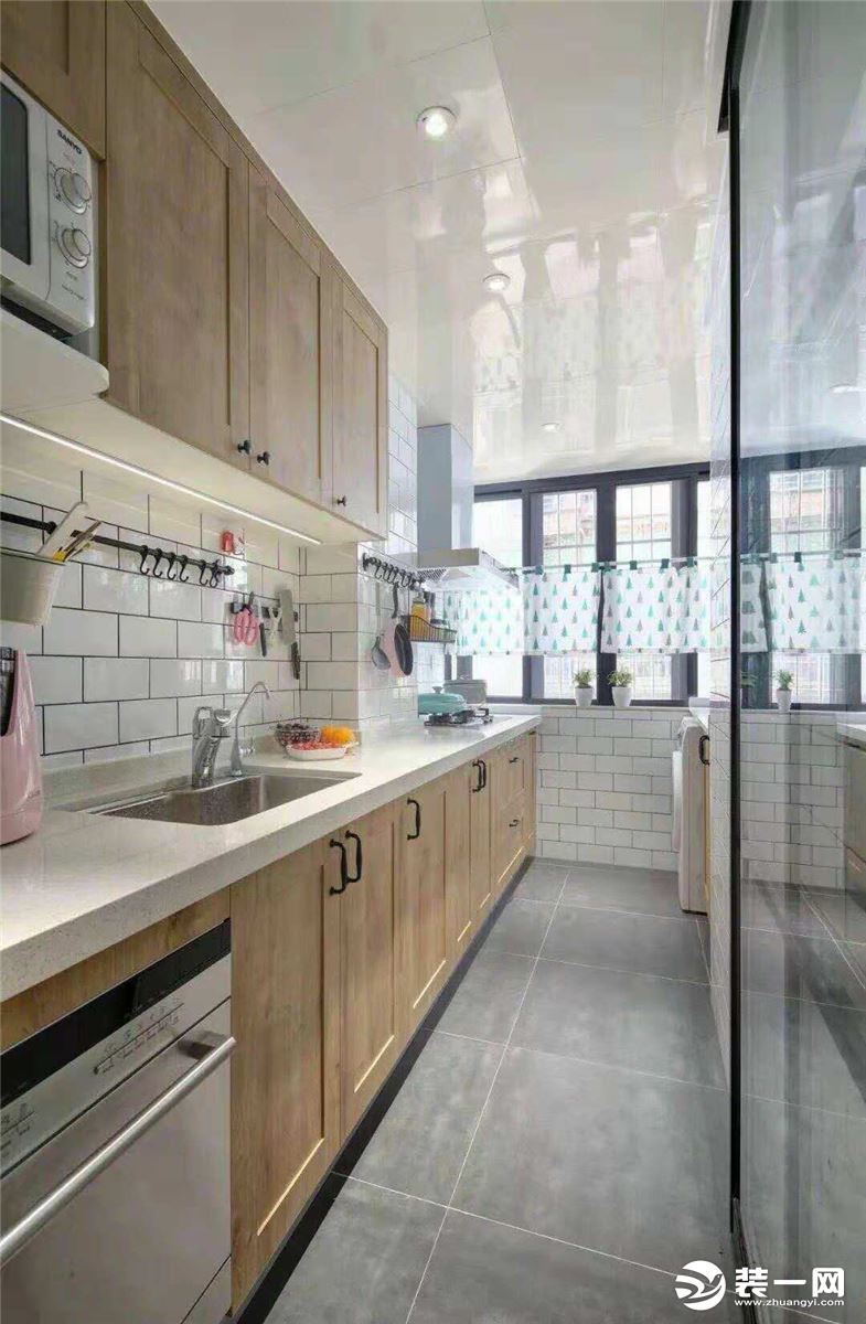 ?厨房宽度也不是很足，所以做了一字型的橱柜，把迷你的生活阳台包进了厨房，洗衣机和灶台放在靠窗的位置。