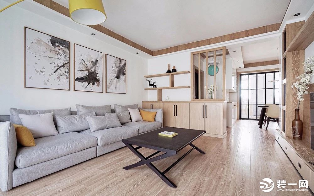 客厅使用大量的原木元素打造舒适柔和的居住感受，门厅与客厅之间用了一组储物柜结合木质隔断的做法来区分。