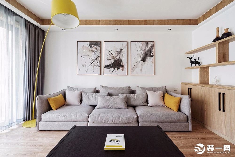 客厅软装搭配上，选用三人座沙发与三组装饰画，用一盏明亮的鲜黄色钓鱼灯，增加客厅的趣味性。