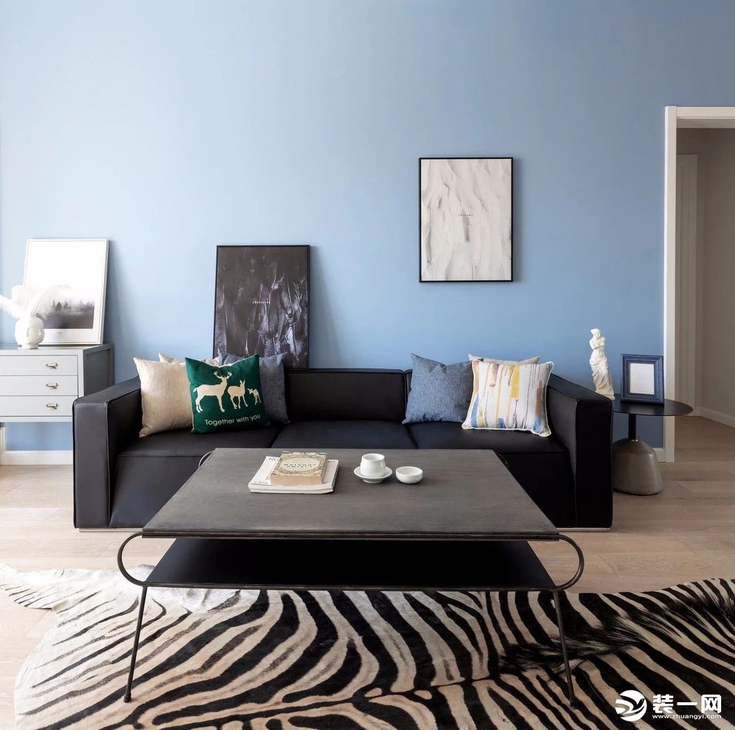 客厅主调是清爽的天蓝色，墙面没有复杂装饰，一黑一白的挂画十分有品位。