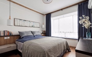 床头设计了半高矮墙，方便收纳常用的物品，窗帘与床品同一色系，蓝色营造静谧舒缓的睡眠空间。