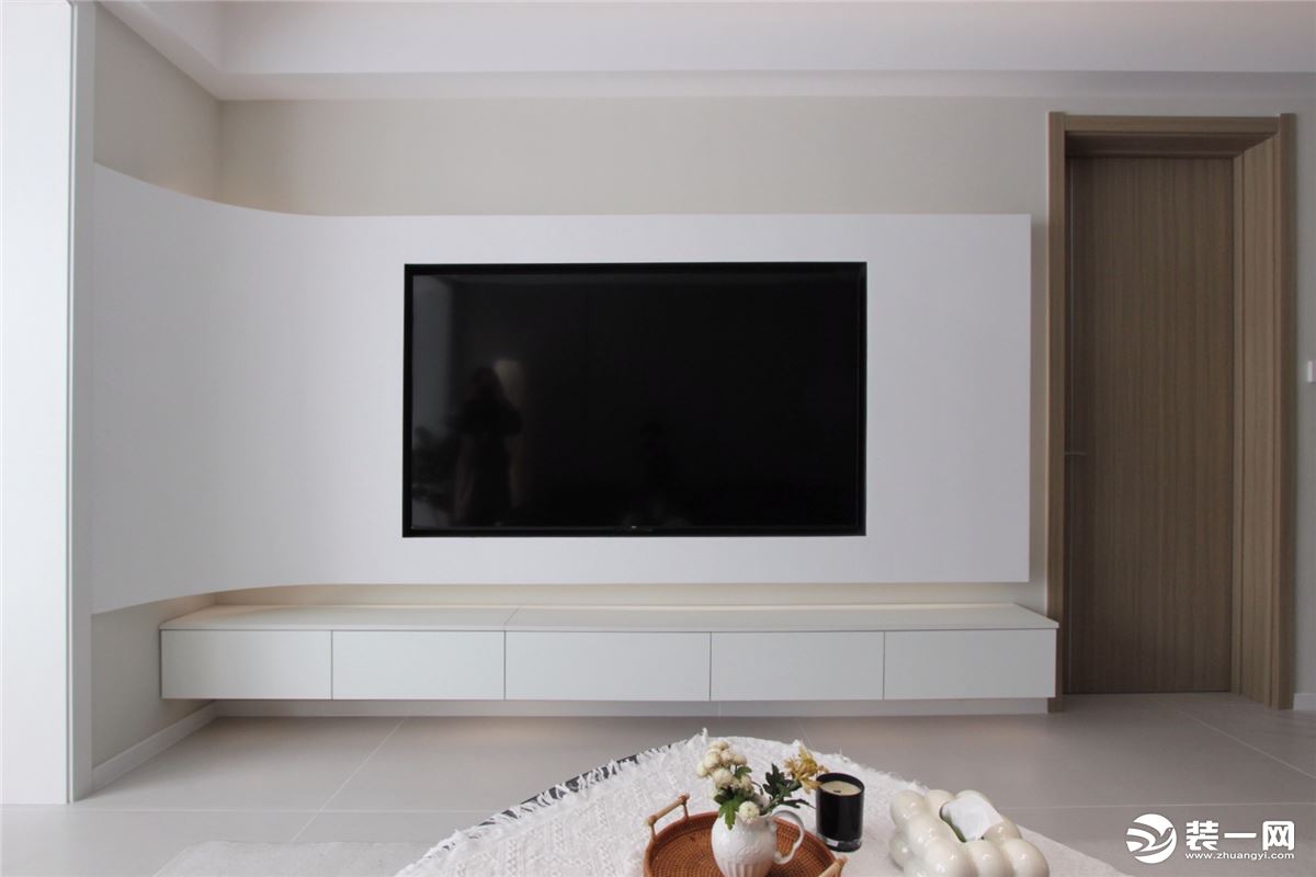 弧形石膏电视背景墙，创造“悬浮”既视感，上下内嵌灯带，简约且高级。一字型悬空电视柜不占地，基本上不会