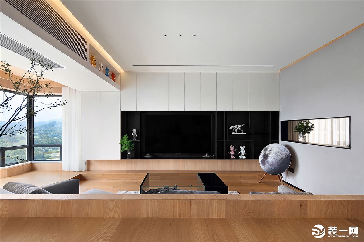 客厅主要采用原木风，电视背景墙是一整排的收纳柜，以白色为主，开放式的展柜则选择黑色，形成颜色对比。