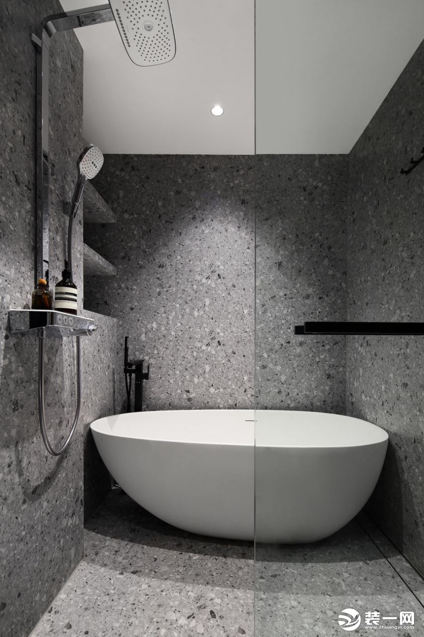 主卫是设计的浴缸加淋浴区，三面环绕颗粒感十足的瓷砖，墙壁内侧壁龛设计，用来摆放洗漱用品。