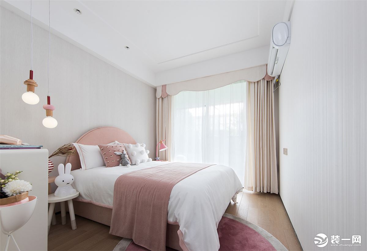 房間以奶白+淺粉色為基調，營造溫馨軟糯氛圍感的空間，淺色軟包床+造型獨特的吊燈，有種誤入童話世界的感