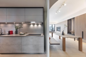 厨房内部的收纳柜选择浅灰色设计和白色的台面较为搭配。上方收纳柜下面设计筒灯照明，相对天花板的吸顶灯来