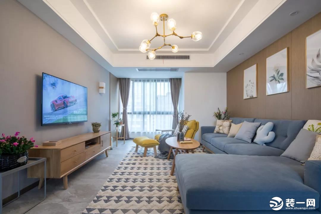 ▲整个客厅以简约舒适的暖色调为主，在灰色与木色搭配下，结合一盏蓝色布艺沙发，带来一个简洁优雅的空间感