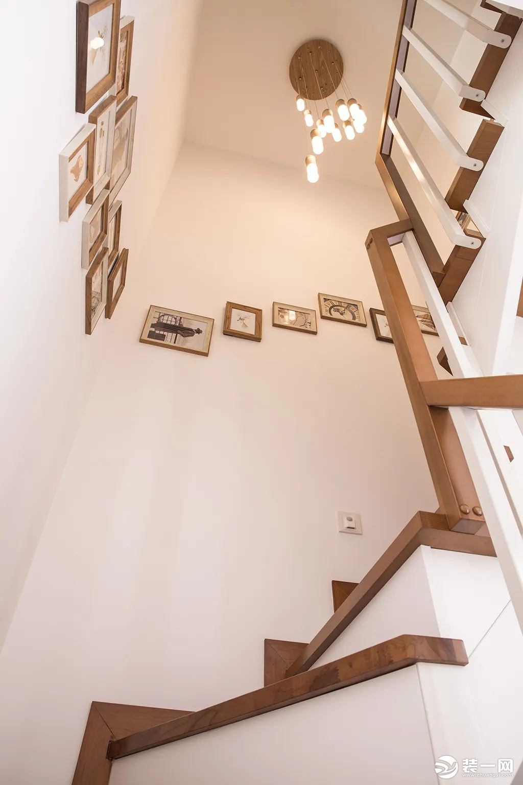 木质踏步与扶手，墙面丰富的挂画，使得楼梯空间充满自然舒适的优雅感。