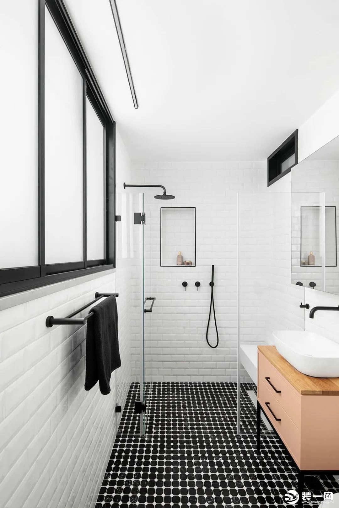 主人卫生间以黑色+白点的地砖，结合白色面包砖墙面，木色洗手盆柜+黑色五金配件，让卫浴空间显得文艺而又