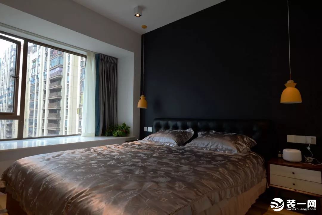 卧室背景墙整体刷成黑色，搭配两侧吊灯设计暖意融融。