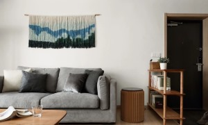 ▲ 选用了一款坐感舒适的沙发，沙发背后的墙面用了一款比较特别的挂饰来修饰整个空间