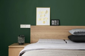 ▲ 次卧的墙纸颜色出挑且沉稳，与浅色系的家居品形成鲜明对比。