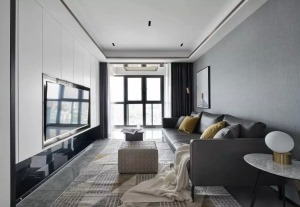 白灰色主色调使得空间更为宽敞明朗，墙壁与家具上直落的线条几何美感，与地毯、装饰品等软饰上曲线的柔软弧