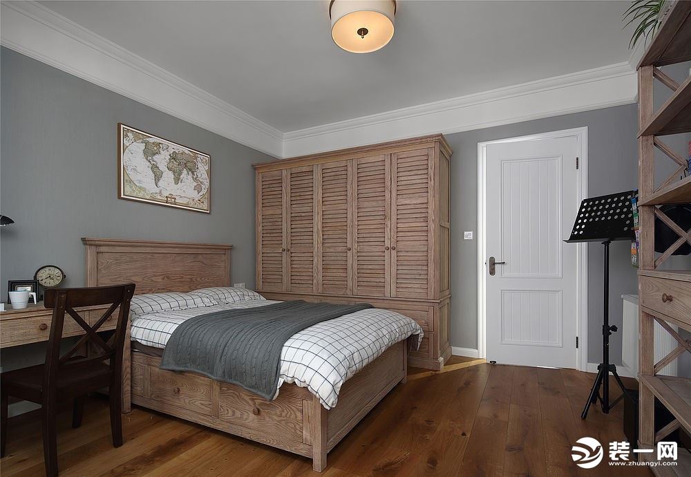 次卧家具色调保持一致，选用了相对较浅的木色，与主卧风格作一区分。灰色调的墙面配以白色床品，透露出些许