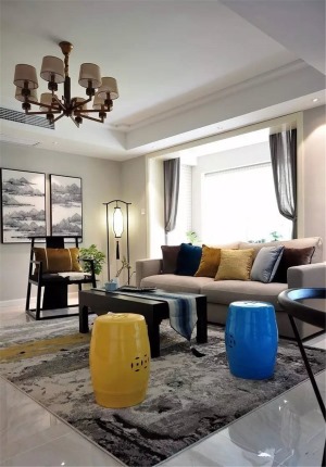 ▲ 一对黄色和蓝色的鼓凳点亮整个空间，所有的家具、配画、装饰都有中式元素