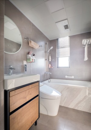 卫生间临窗设置了浴缸，白色哑光大理石搭配灰色亮光墙地砖，整体简约舒适。