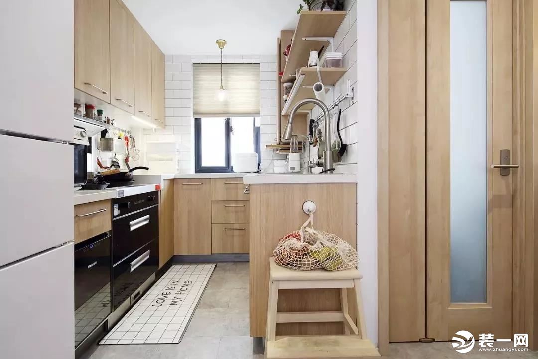  厨卫都在黑框玻璃推拉门后方，厨房采用U型格局将台面和收纳空间最大化。