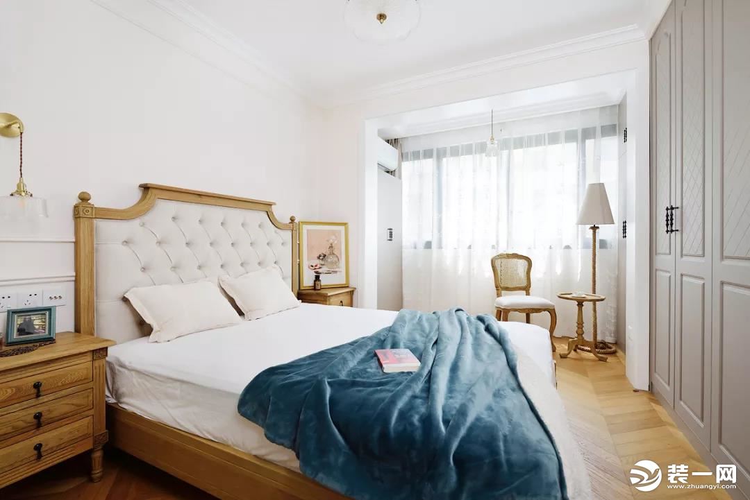  卧室延续了客厅的整体风格，一张复古大床占据了视觉中心位置，搭配蓝色丝绒盖毯，营造出别样的优雅氛围。