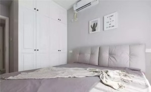 主卧室的床头背景墙也是以浅灰色为主，和这个软包床头相互呼应，到顶的白色柜子可以避免让卧室空间看起来太