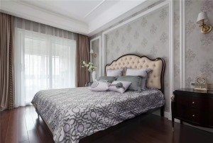 次卧墙面用木饰面做装饰，浅色花纹也使空间更有层次变化，选用较为简约的床品突出平实的生活理念。