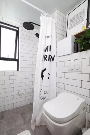  浴室同样采用墙面白砖工字铺贴+水泥质感地砖，马桶与淋浴区则用浴帘进行分隔，轻便美观易于更换。