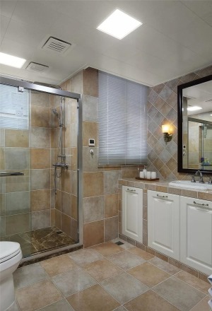  卫生间瓷砖色调雅致，超大落地式浴柜满足储物需求。利用玻璃进行干湿分离，使视野更加通透，同时防止湿气