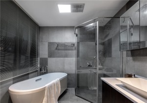 卫生间以灰色瓷砖为主，搭配白色洁具，及深色浴室柜，让卫生间也能有丰富的层次感