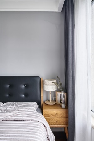深灰色棉麻窗帘与亚麻色的灯罩相辉映，给空间增添了一丝静谧之美。