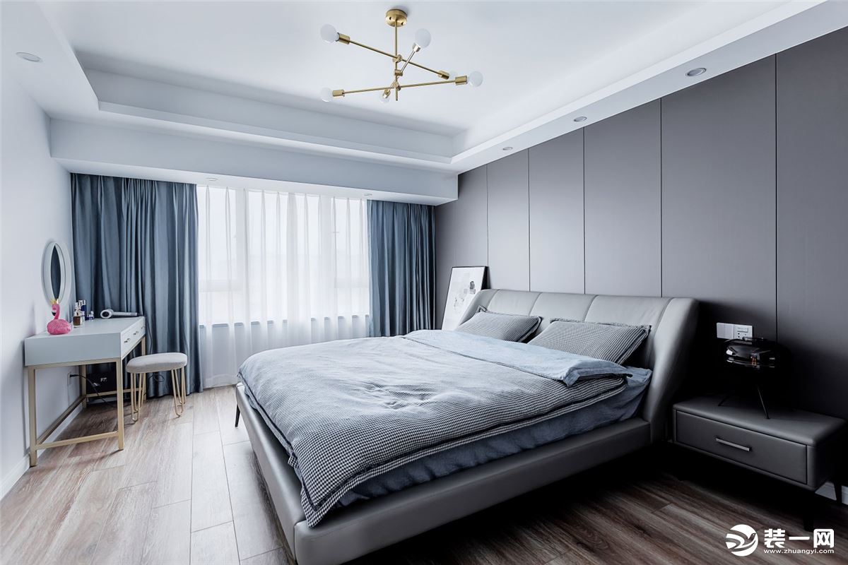 整个主卧的灰色调里，用蓝色窗帘点缀。 深灰色饰面作为床头背景，同色系的撞色，更显空间的质感和档次。