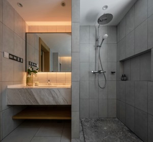 卫生间采用灰色墙砖与地砖，面盆台面采用大理石，材质的对比和融合，功能细节的暗部表达，是卫浴空间的核心