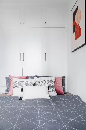 ▲ 次卧面积较小，靠墙安装了定制的榻榻米床，搭配灰色床品与粉色抱枕、挂画，呈现出简约而优雅的氛围感。