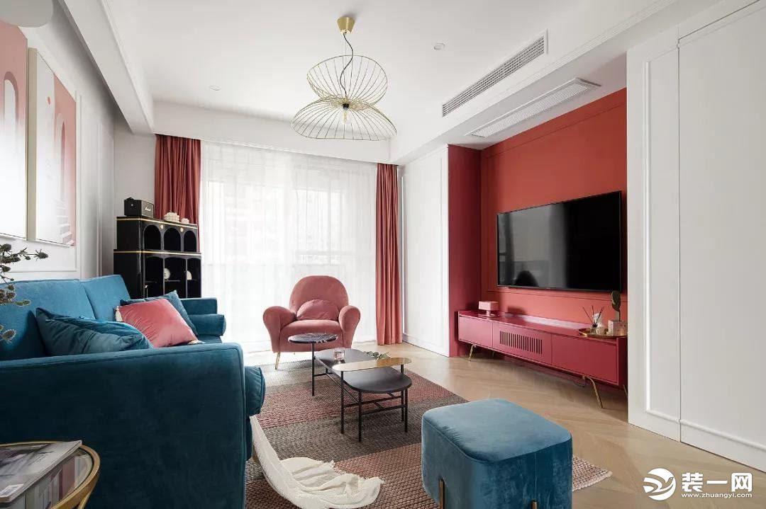 客厅入眼就是红色电视墙和蓝色沙发，极具复古摩登感。