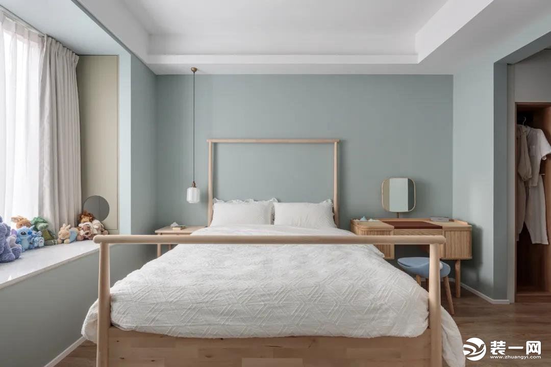 卧室背景墙是清新的绿色，木质床铺风格简约。