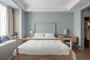 卧室背景墙是清新的绿色，木质床铺风格简约。
